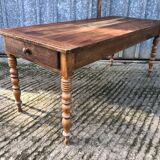 Antique farmhouse table in solid cherry wood with turned legs.
