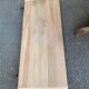 Round extendable dining table stripped in solid raw walnut with a central leg.