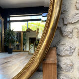 Oval mirror with pediment, beaded gilded with gold leaf