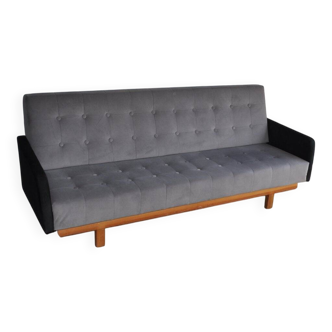 Mid-Century 1960s canapé in grey fabric with black armrests, natural wood base.