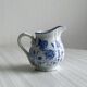 White porcelain milk jug with blue floral designs.