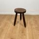 Small brutalist tripod stool in solid wood.