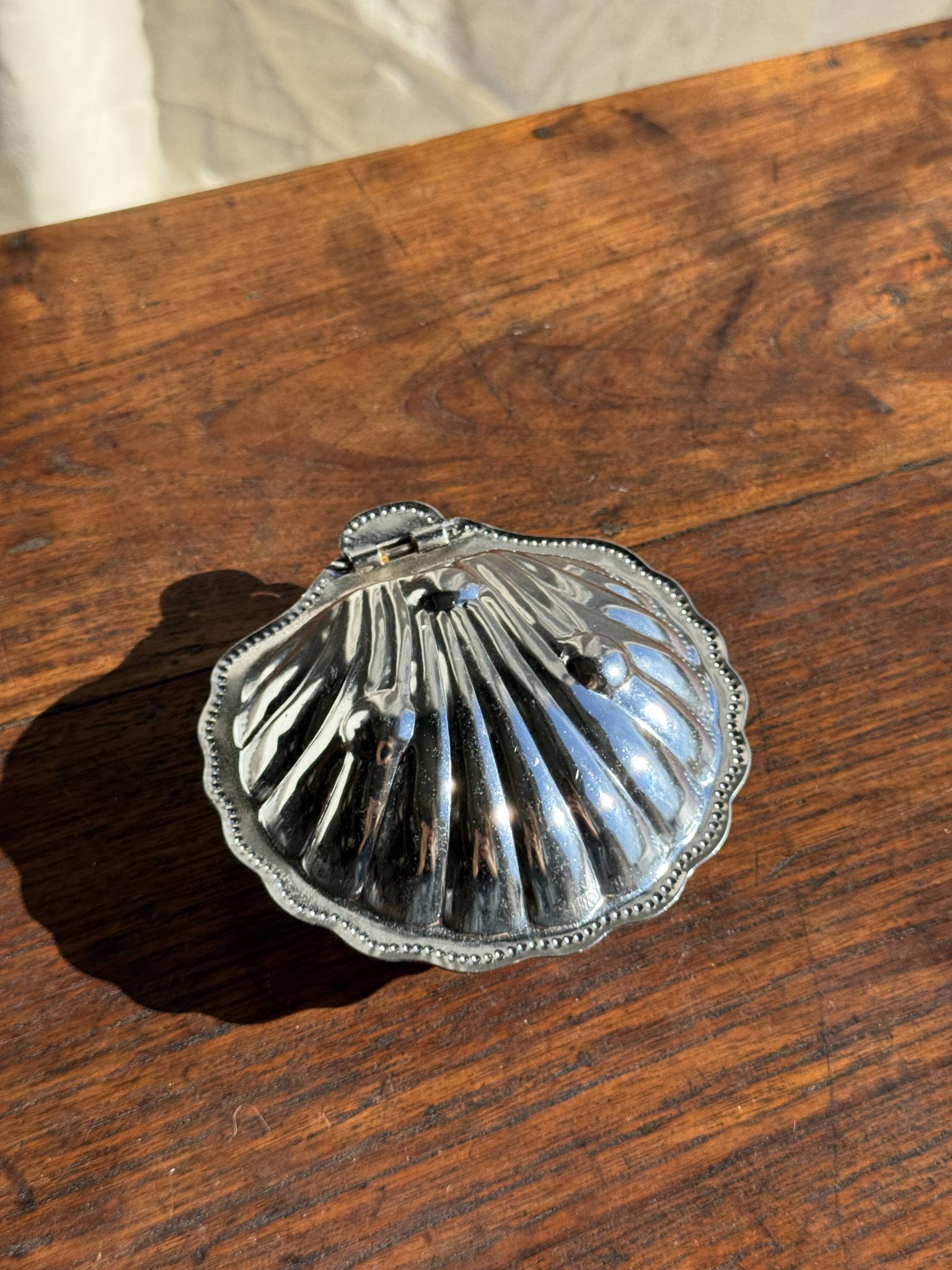 Vintage silver-plated shell butter dish with blue bowl.