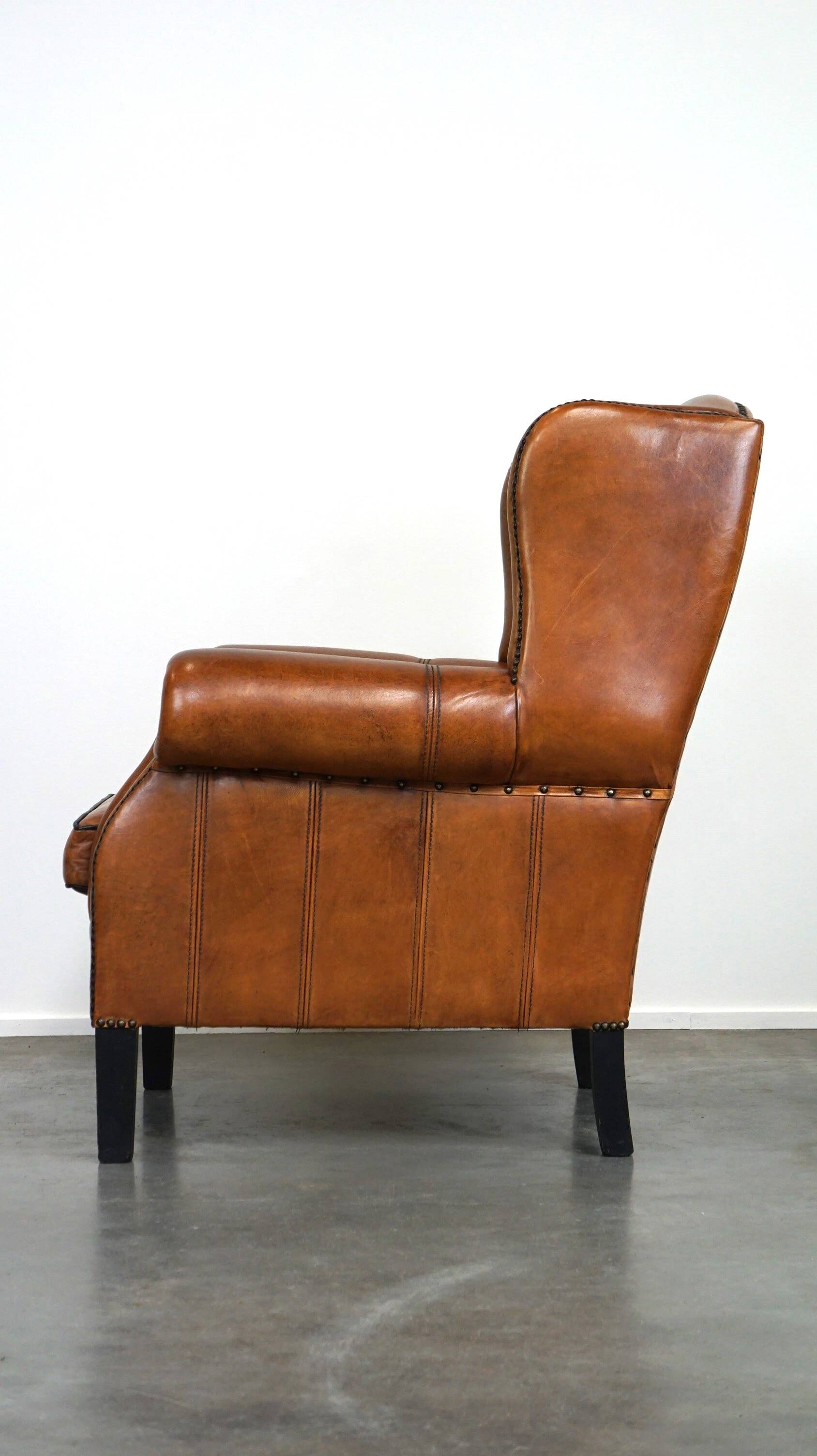 Très beau fauteuil à oreilles en cuir de mouton avec des détails époustouflants