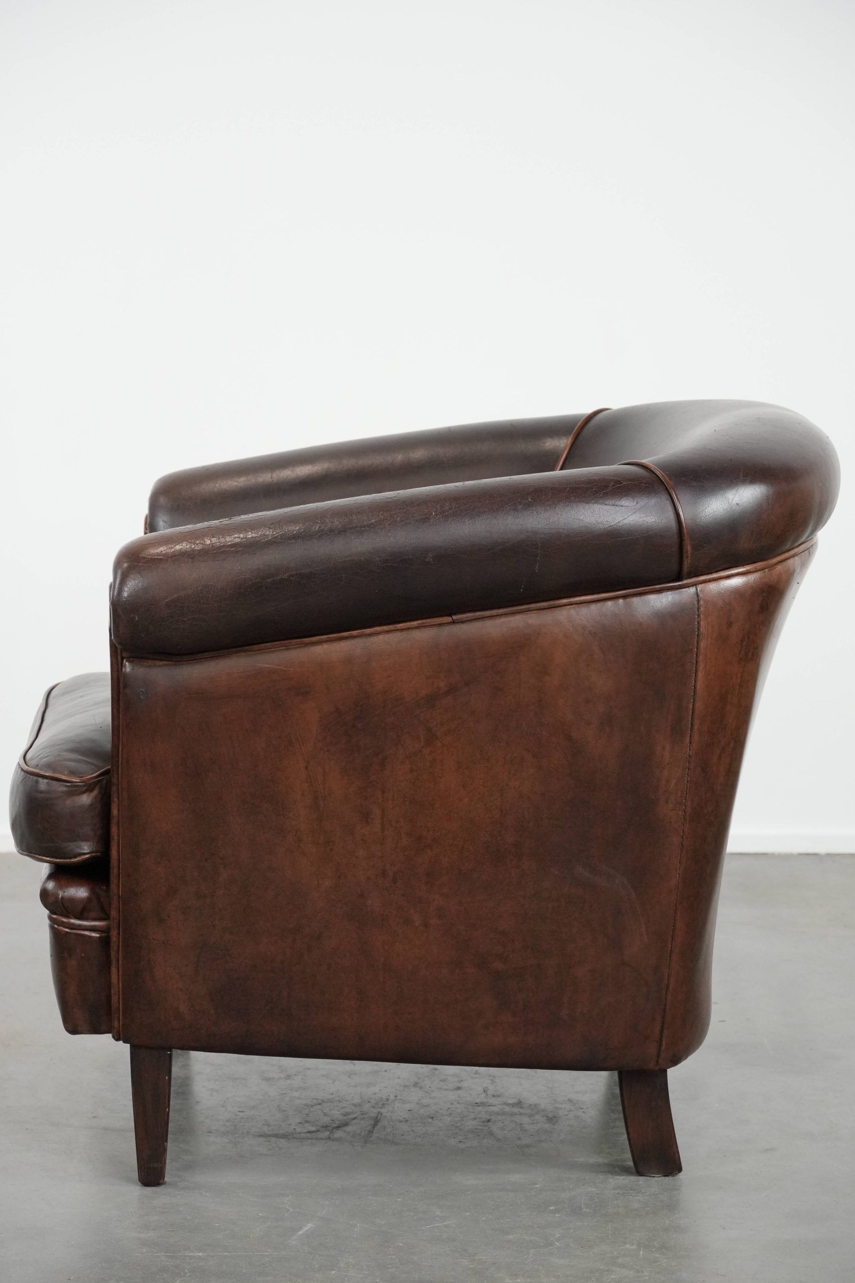 Dark brown vintage club armchair in English style made of sheepskin leather
