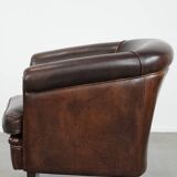 Dark brown vintage club armchair in English style made of sheepskin leather