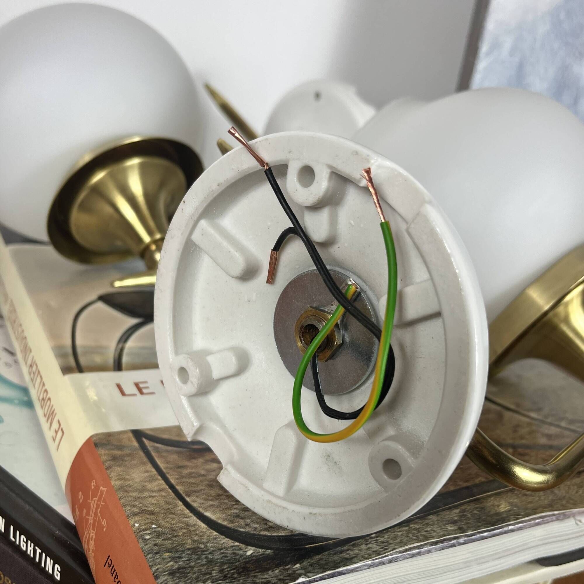 Pair of vintage wall sconces in brass with white glass globe shades.