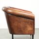 Sheepskin club armchair with deep warm colours and black piping