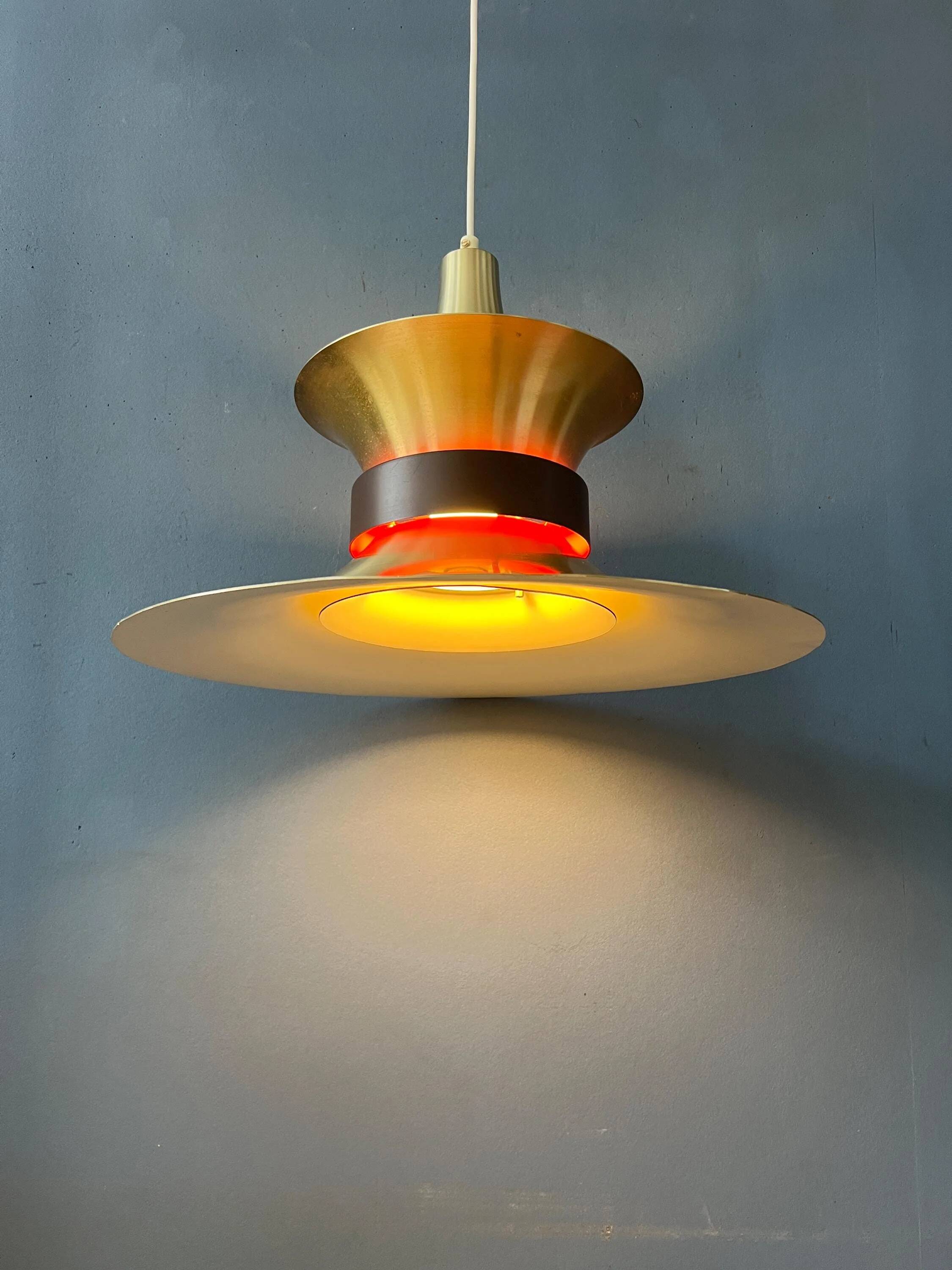 Large UFO flying saucer pendant light with orange light.