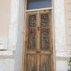 Front door of a house or building in the city centre, with a dolphin door knocker and frame + transom.