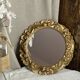 Round wooden mirror in golden colour.