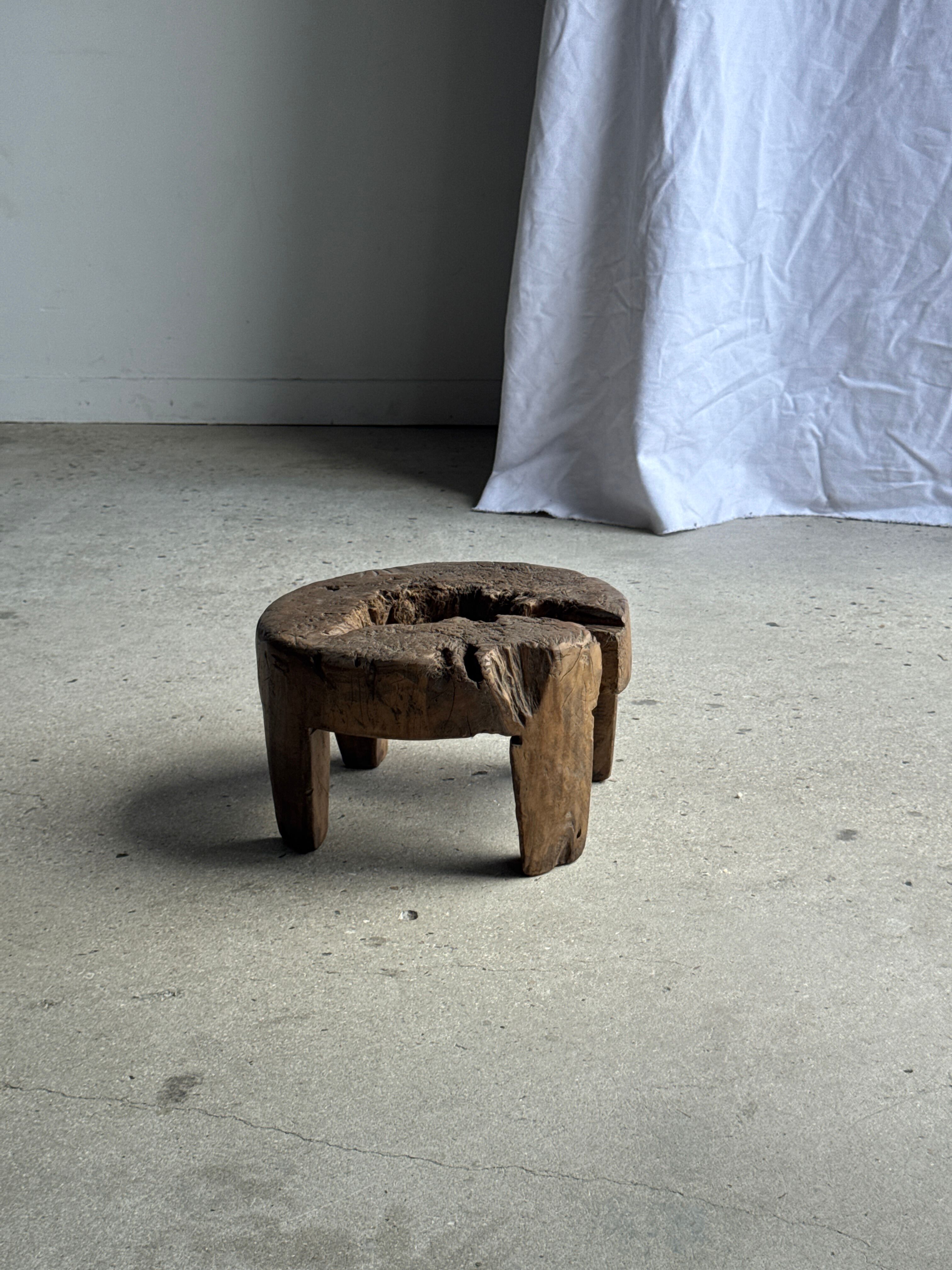 Small low circular four-legged stool in organic old teak with cut-out design H2