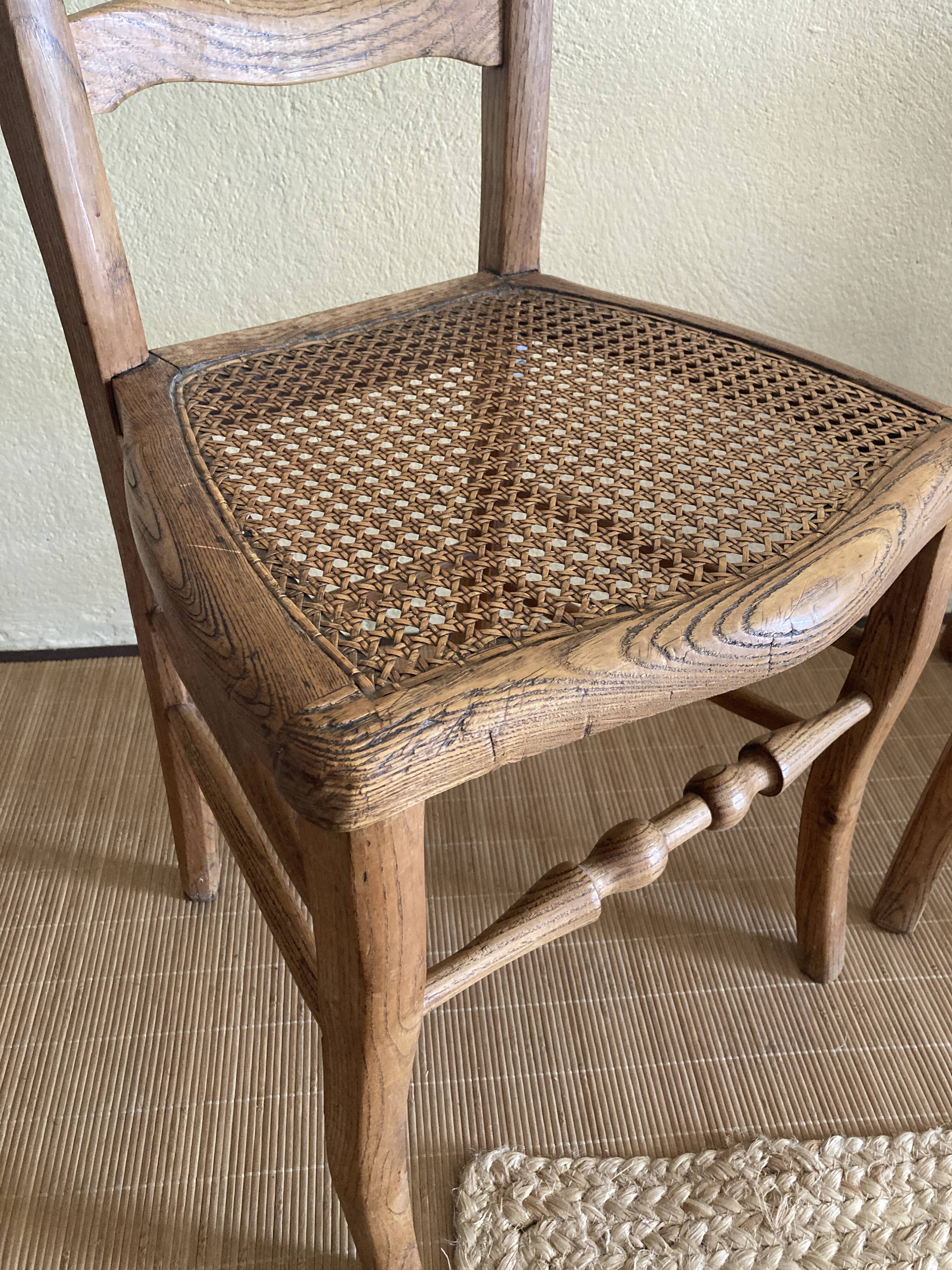 Set of two antique chairs with caning.
