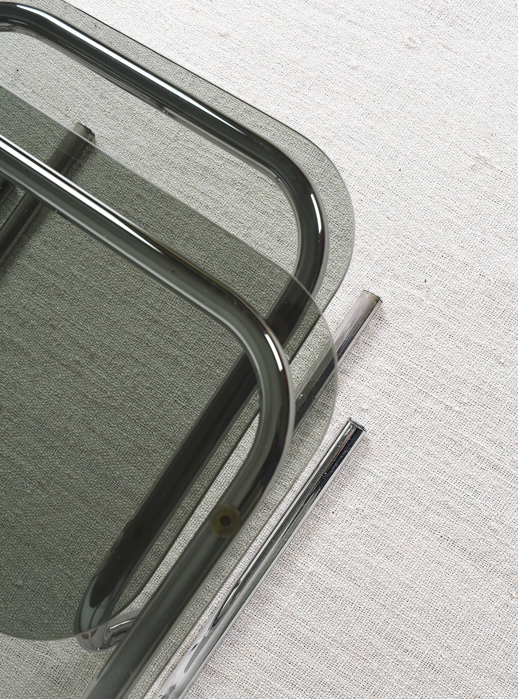 Pair of nesting tables in smoked glass and chrome legs.