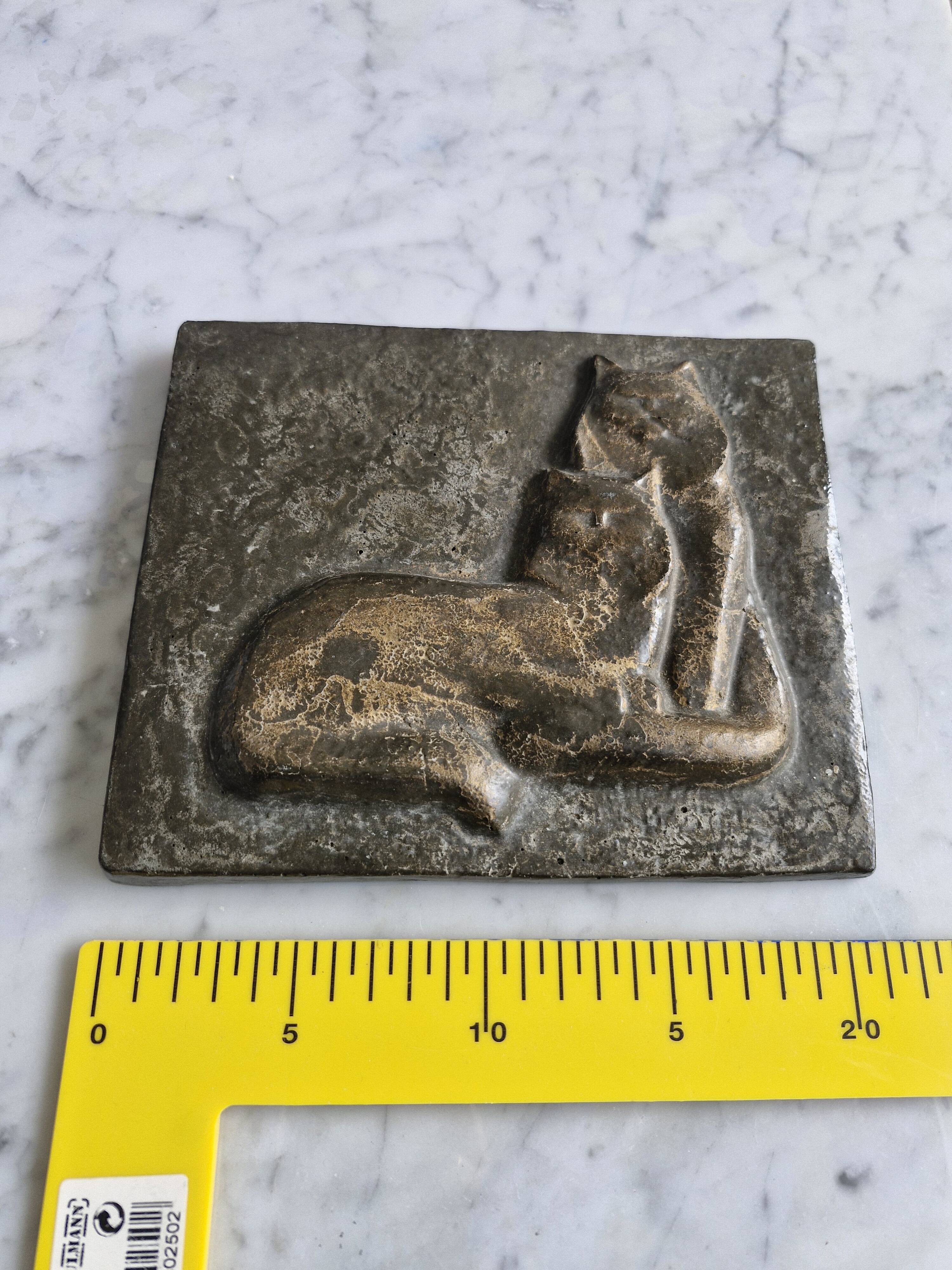 Bas-relief plaque of a rabbit in brown patina, seated cat