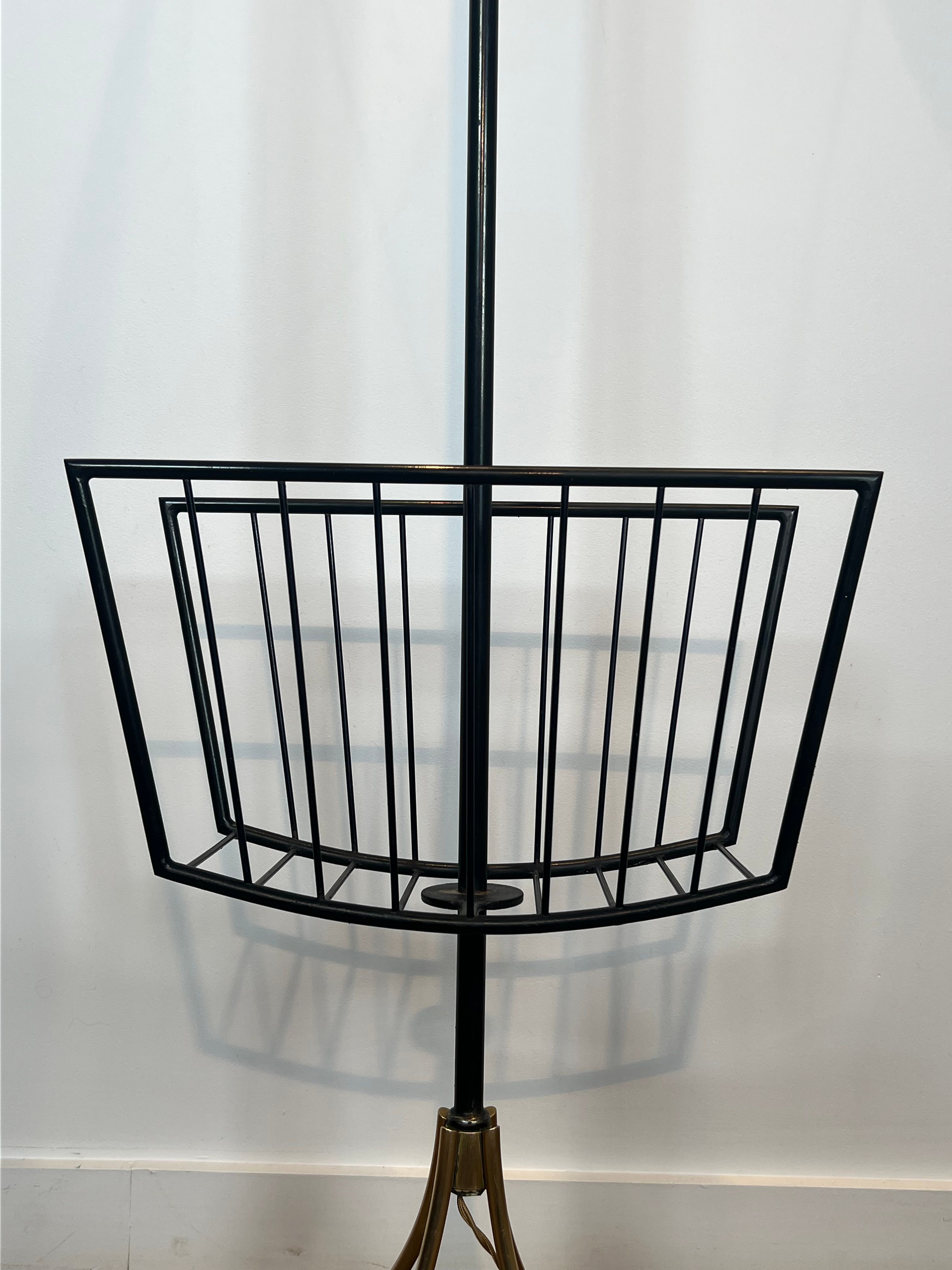 Designer floor lamp in black lacquered metal and brass, incorporating a magazine rack