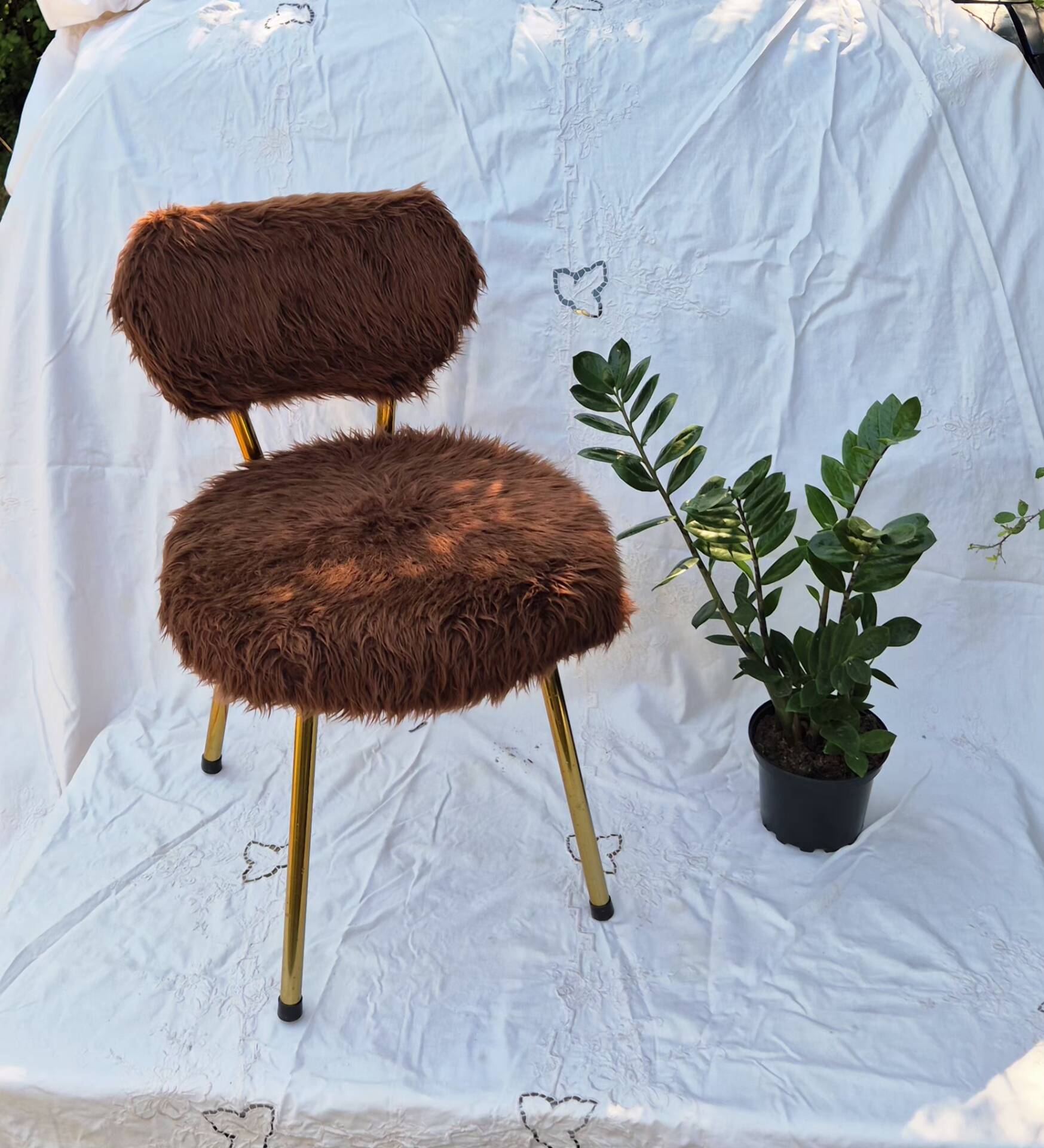 Vintage shaggy chair in faux fur with golden metal legs.