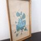 Decorative table with vintage blue flowers in a golden frame.