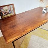 Table with tubular metal legs and wooden top.