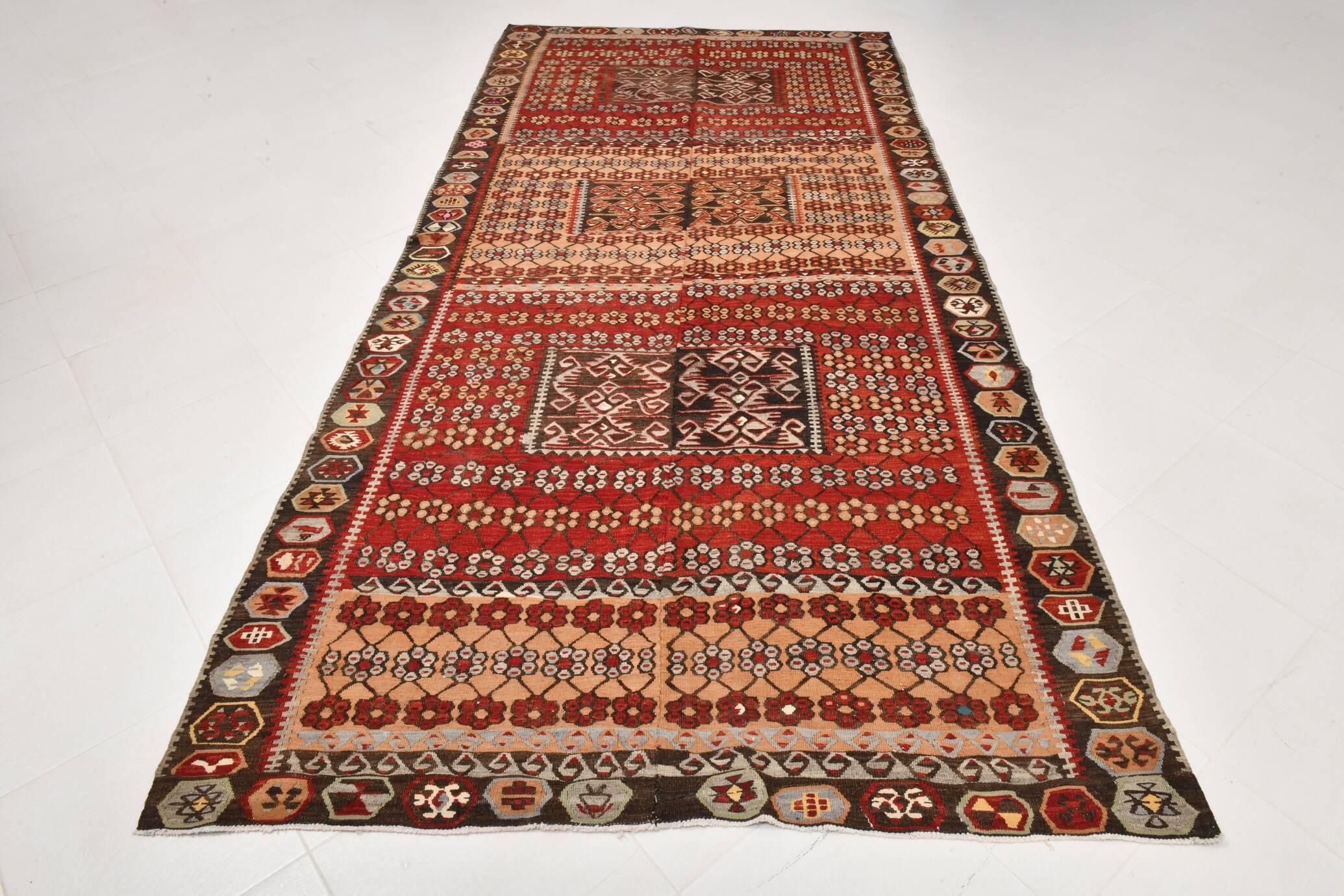 Kilim anatolien ancien tons rouges et beiges, motifs tribaux colorés