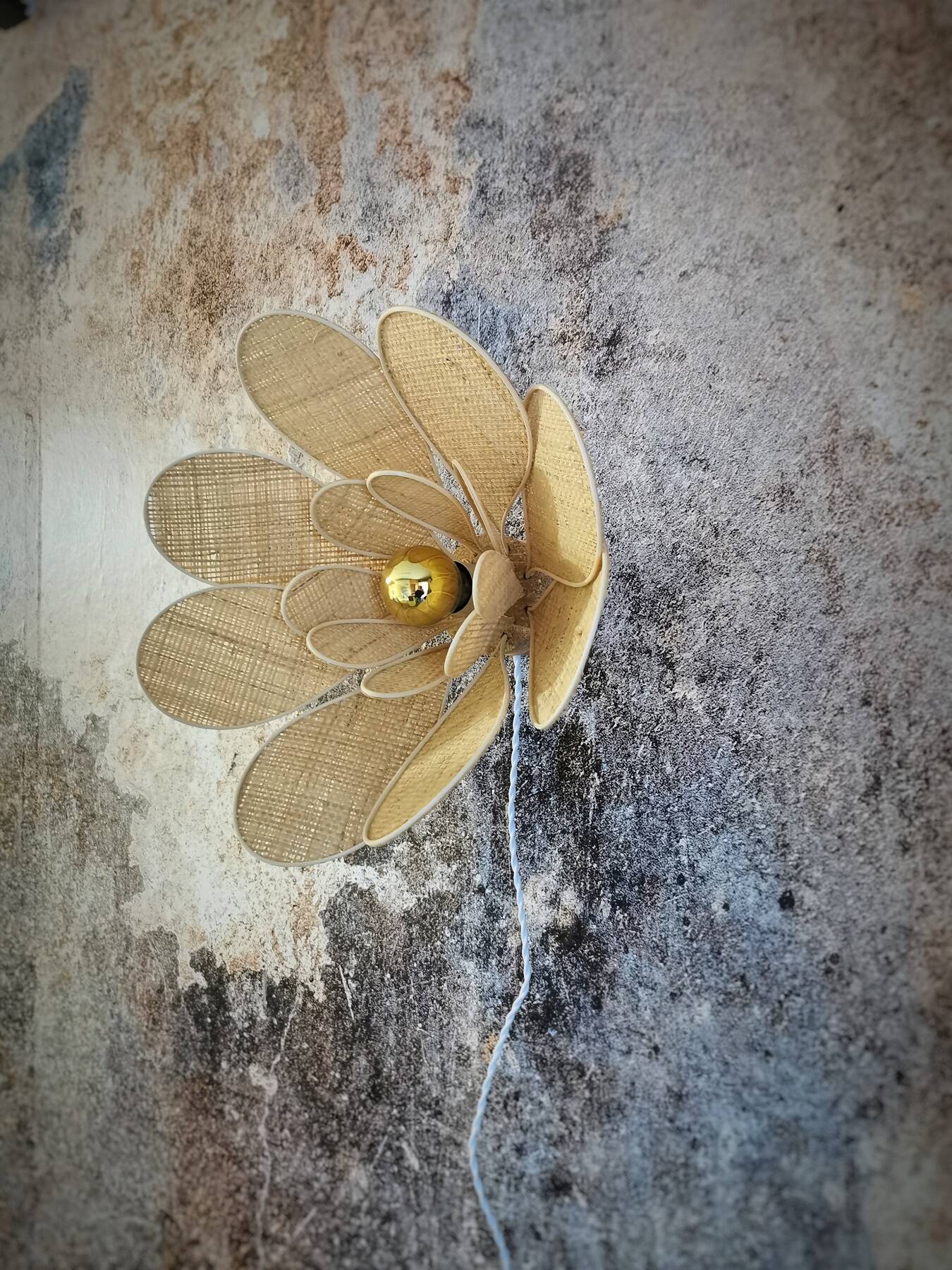 Flower wall light made of rattan and raffia petals