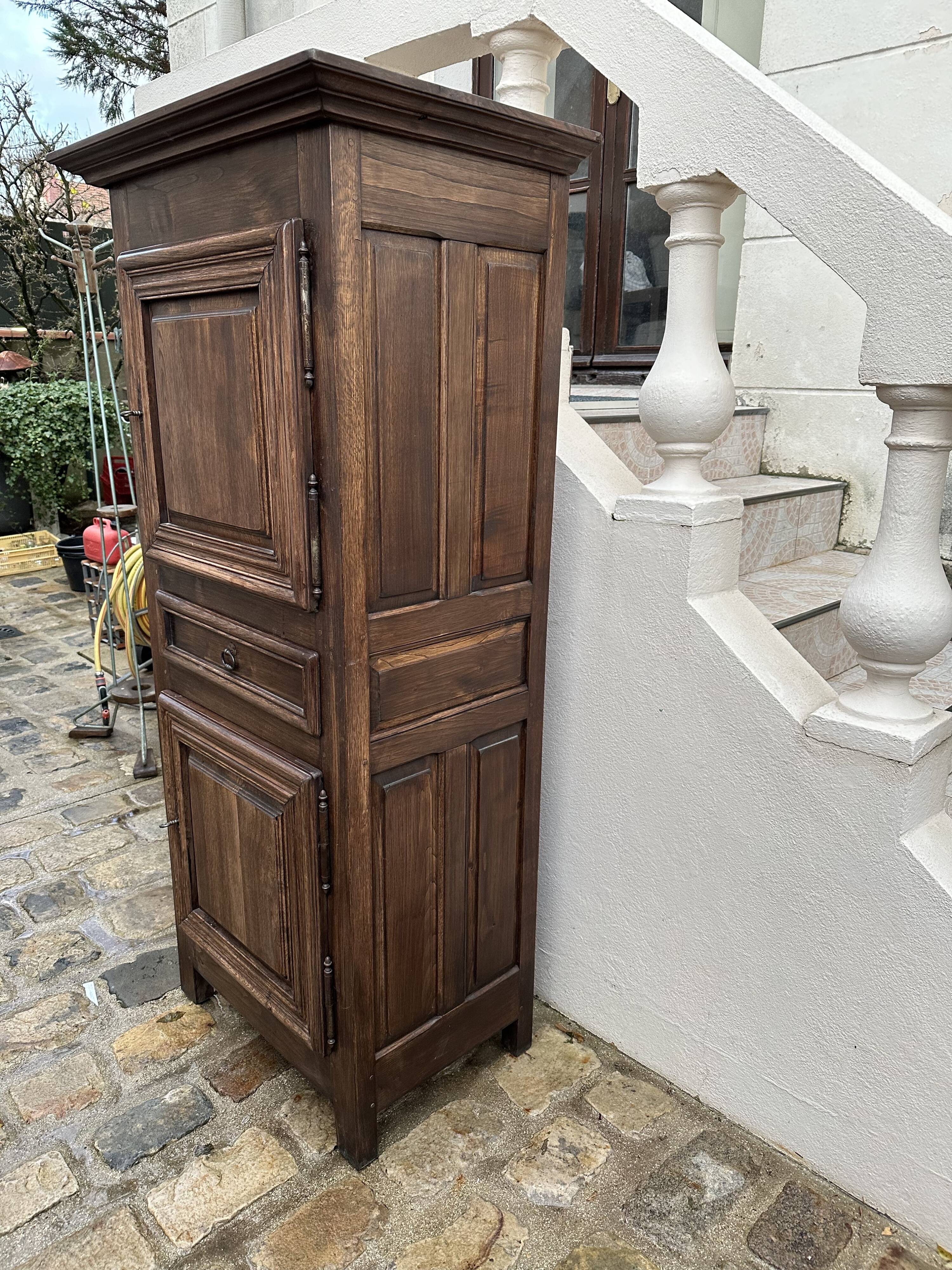 Homme debout armoire étroite à deux portes avec un tiroir central