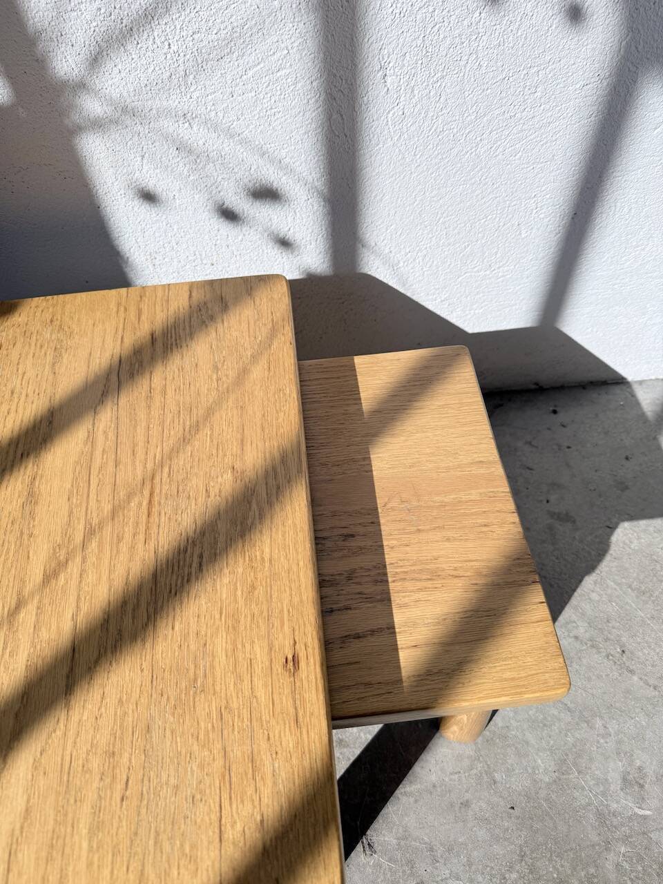 Two stools or small nesting tables in light oak.
