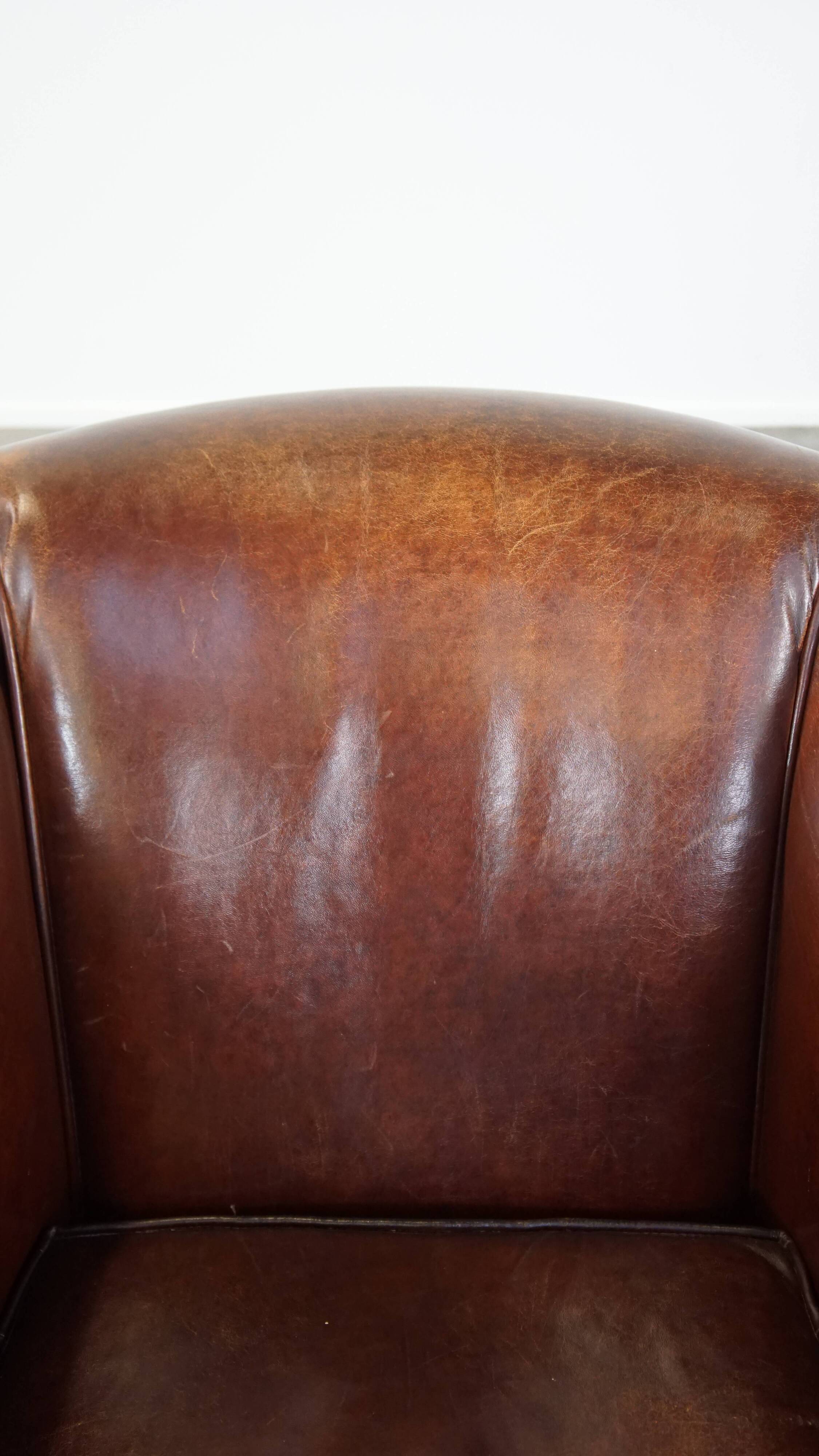Sheepskin club armchair, correct finishing with decorative nails
