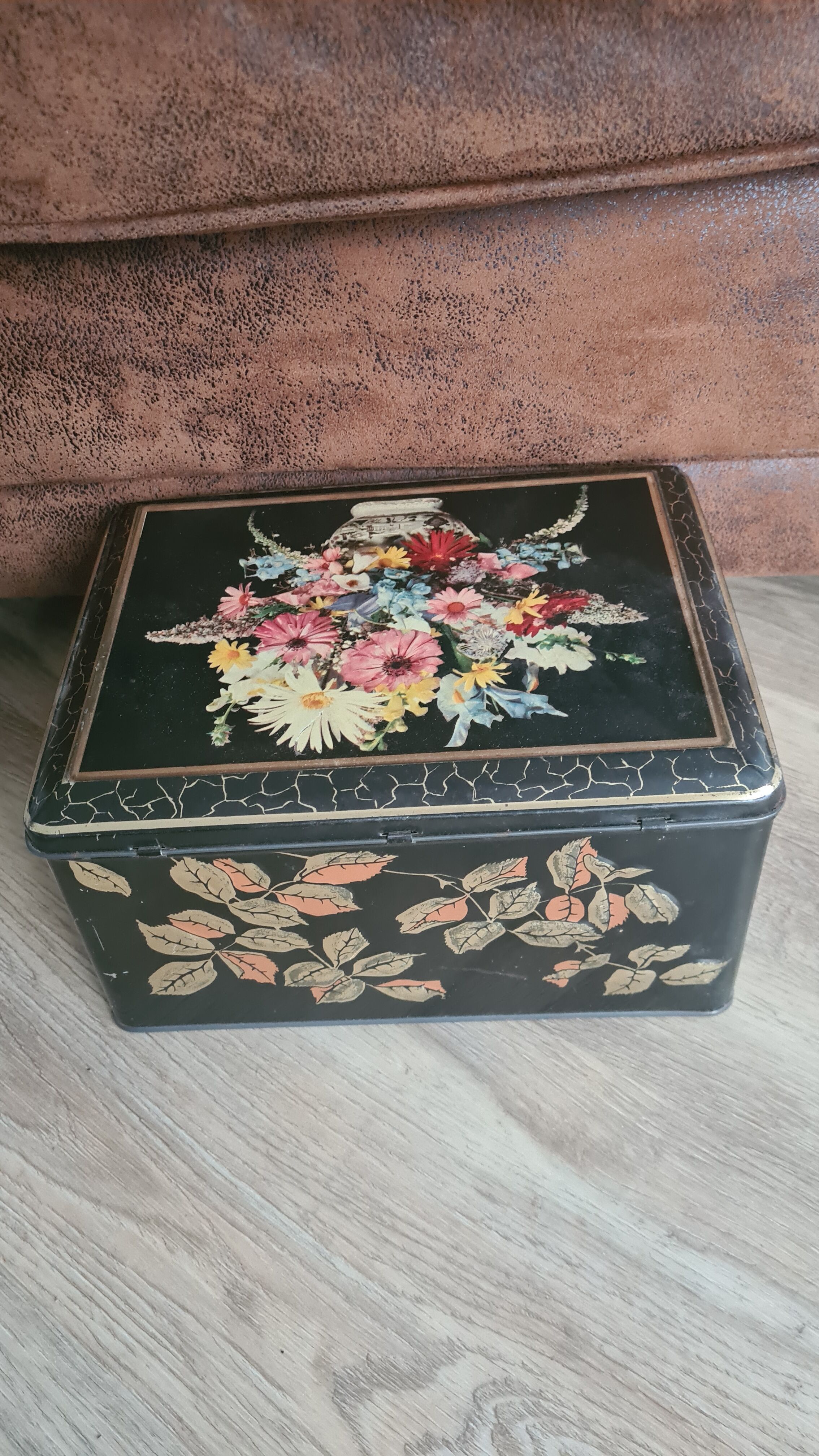 Old black metal box and flowers at the beginning of the century