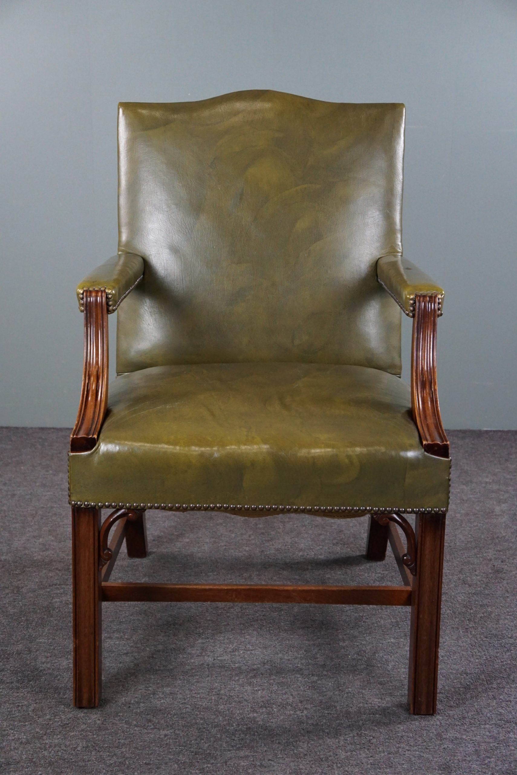 Elegant armchair and footrest in English green leather