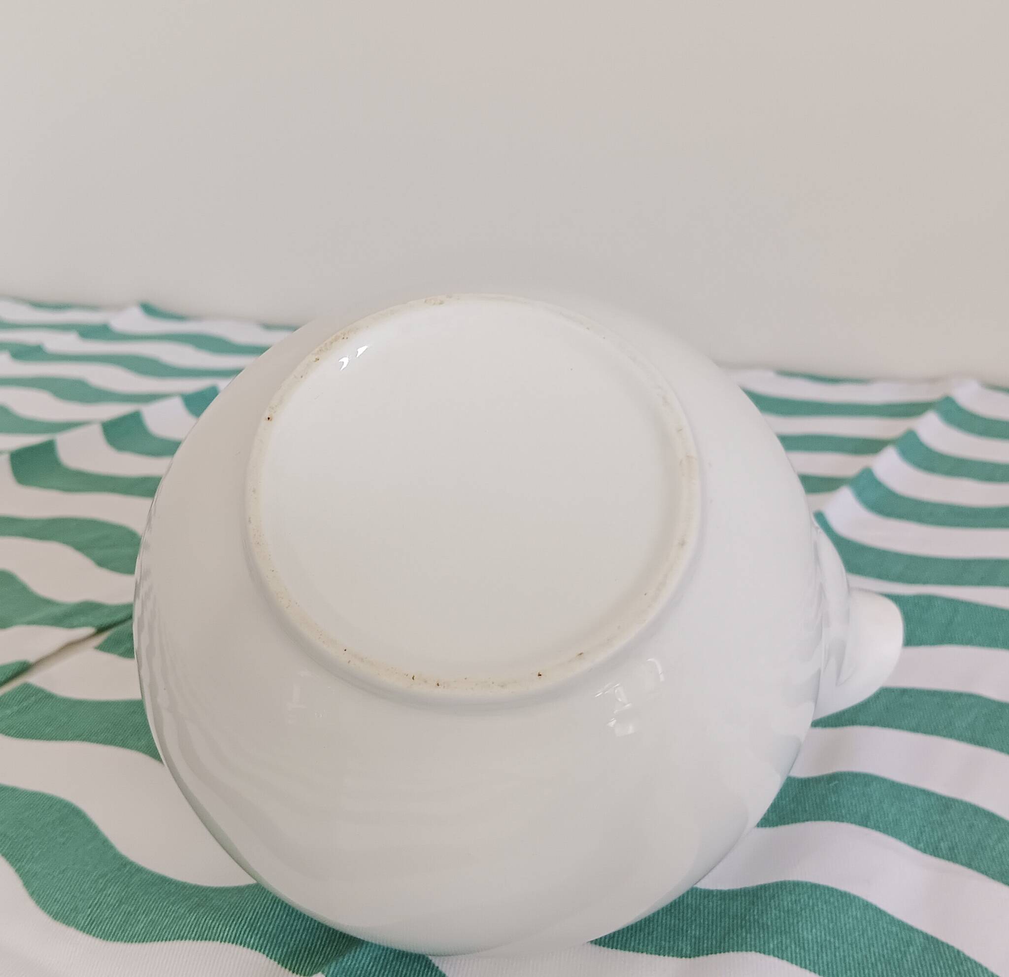 White porcelain teapot. Shiny stainless steel handle and lid