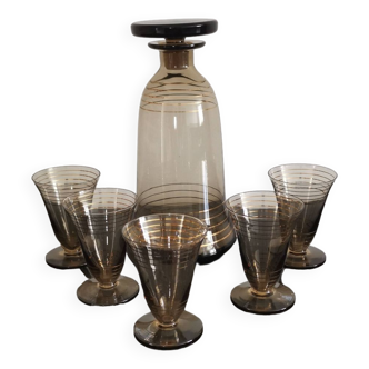 5 liquor glasses on legs and their smoked glass carafe with gold edging