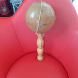 Grand bilboquet en bois clair.