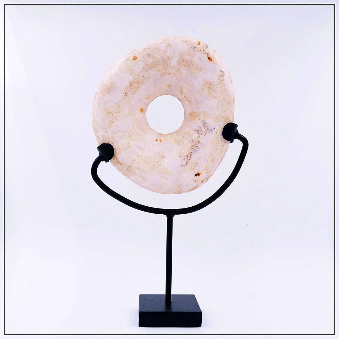 "Wamayuwa" Boiken coin in hand-carved shell mounted on a black metal stand