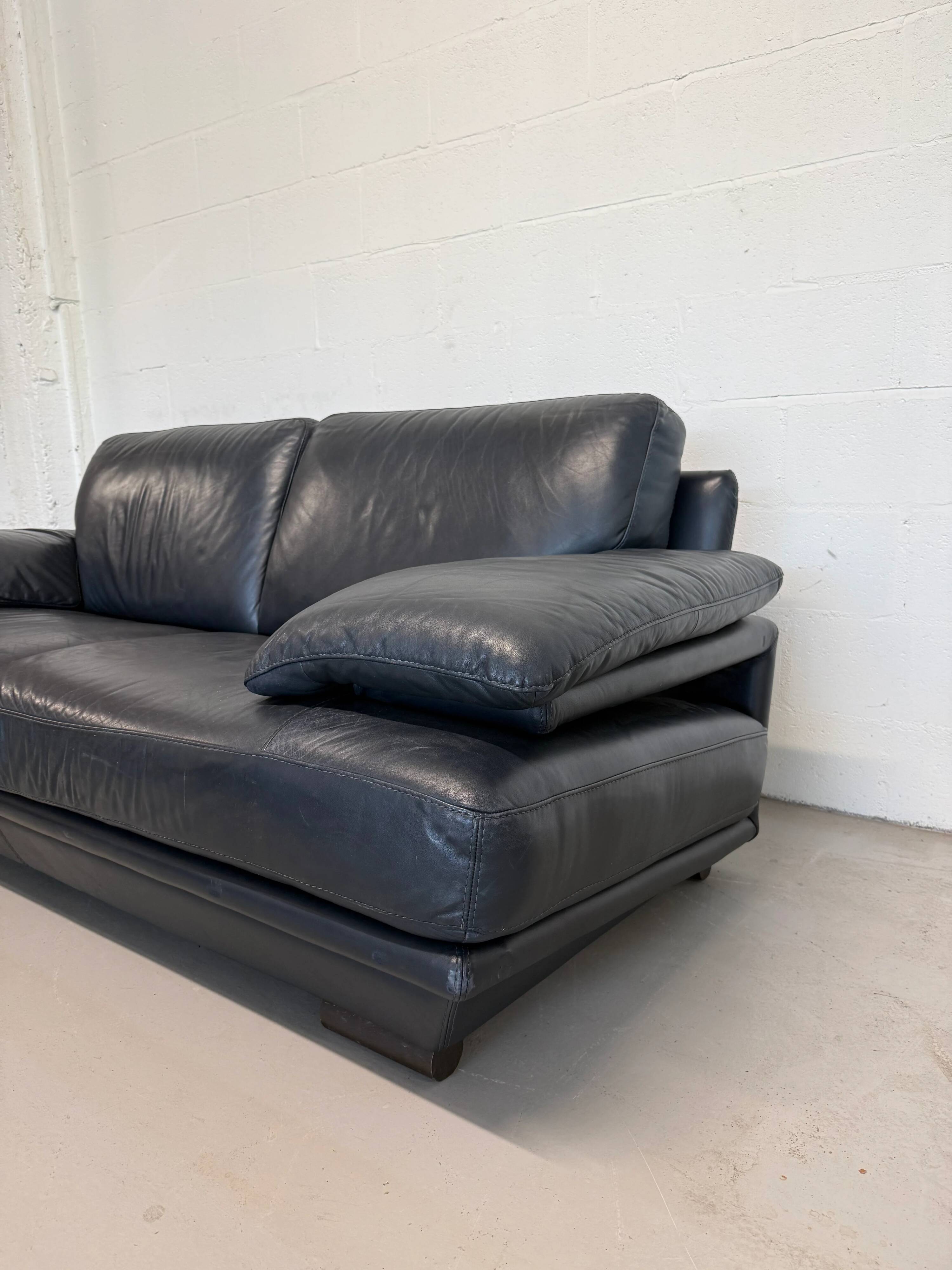 Two-seater Natuzzi sofa in navy blue leather.