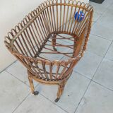 Vintage rattan bed on wheels cradle