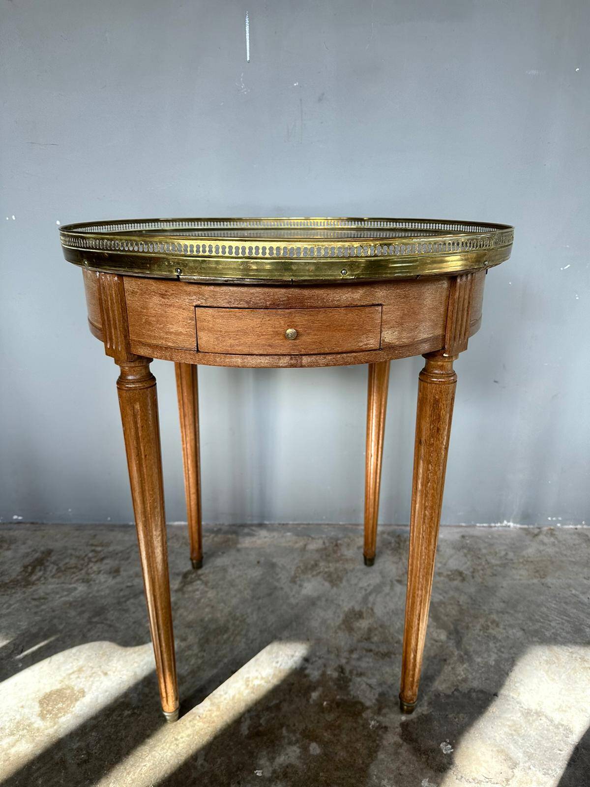Hot water bottle table with a marble top and a brass gallery.