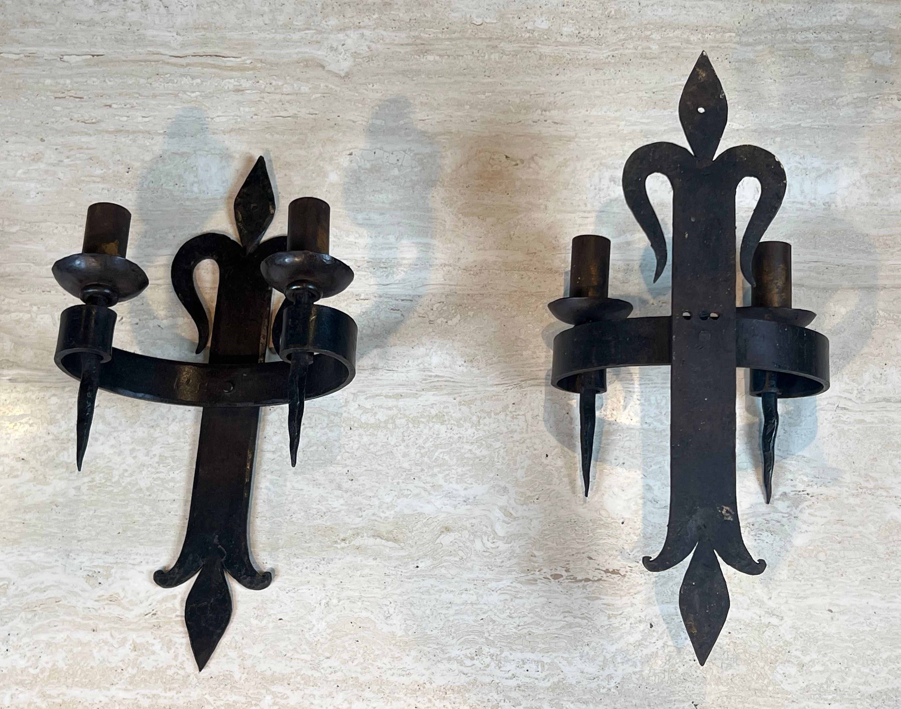 Important pair of wrought iron wall sconces "with fleur-de-lis" featuring 2 light arms in Gothic style.