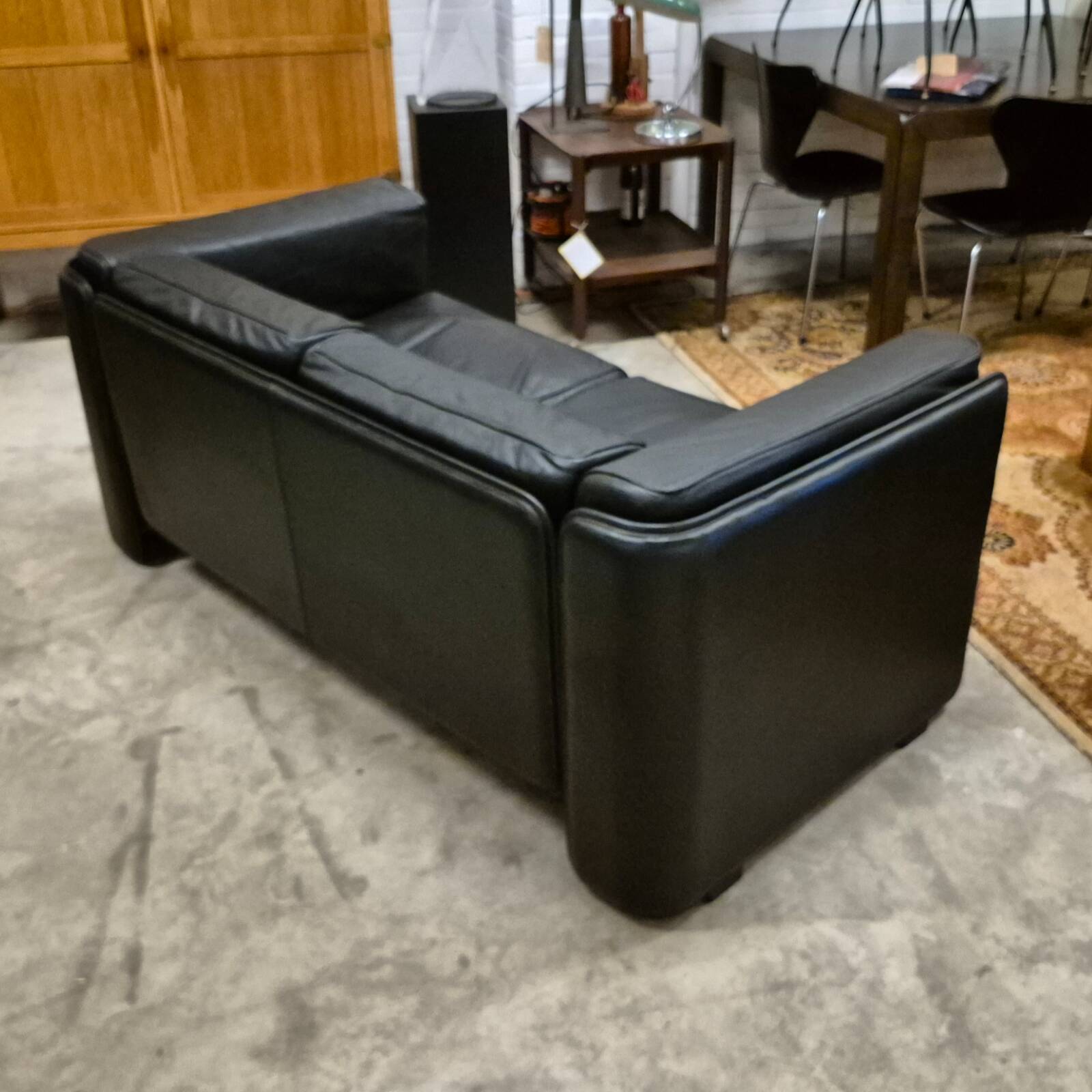 Two-seater sofa in black leather, designed by Tito Agnoli for Poltrona Frau, Italy, 1980s