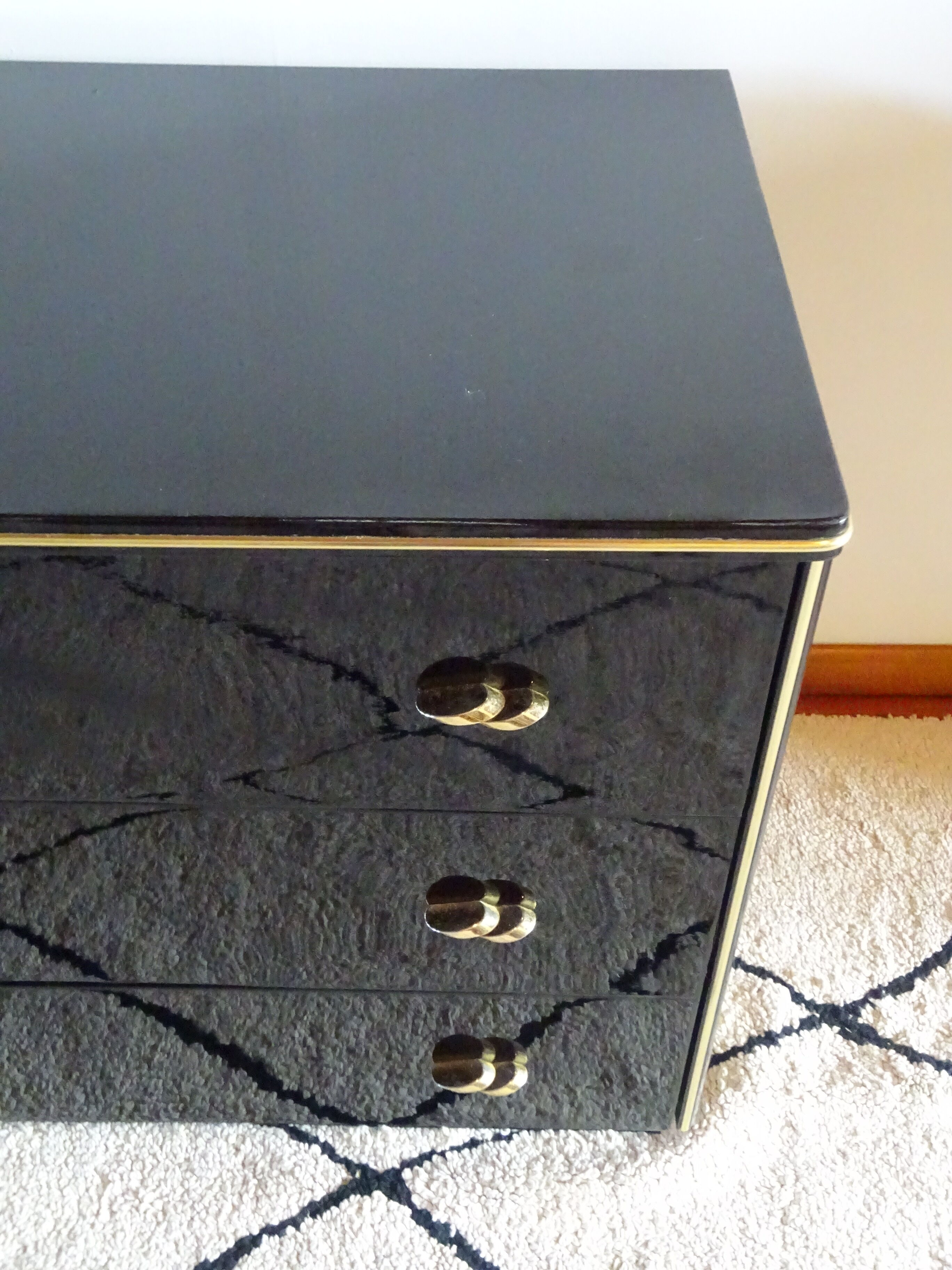 Lacquered black chest of drawers, golden brass