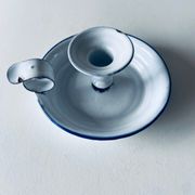 Old candle holder in white enameled metal
