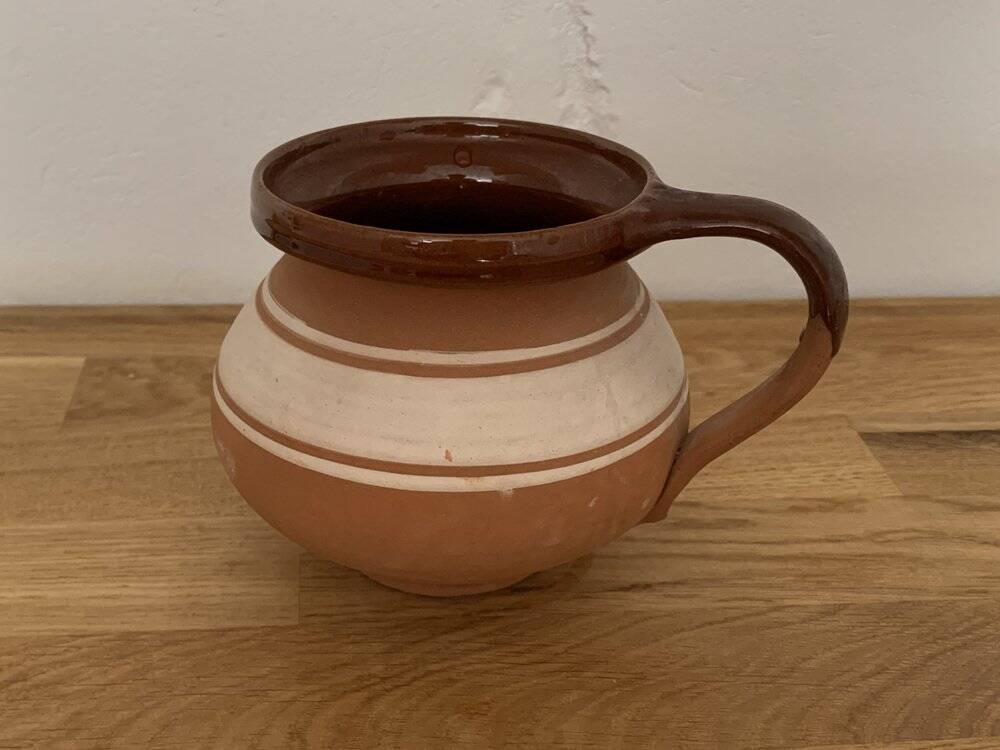 Hungarian folk ceramic pitcher in glossy brown and beige, traditional rounded pot.
