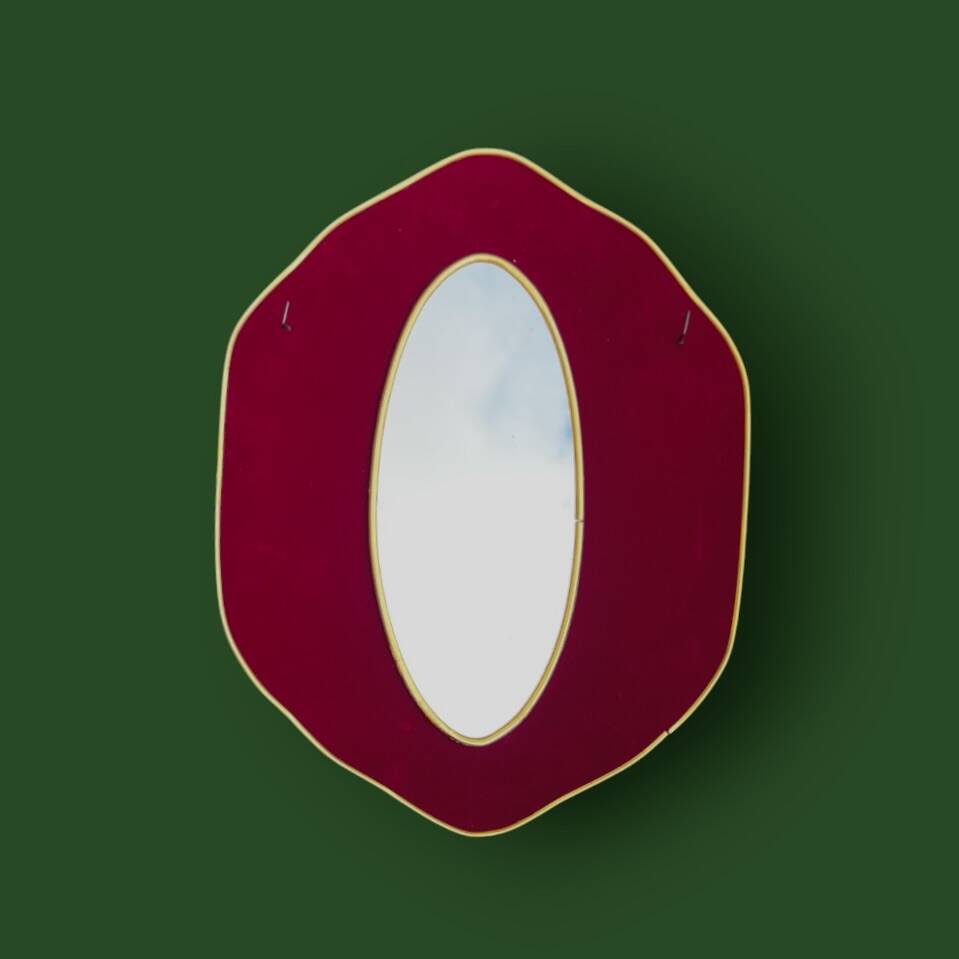 Oval wall mirror in burgundy velvet and brass – 1950s–1960s