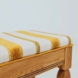 Vintage oak bench with striped linen fabric in a country style.