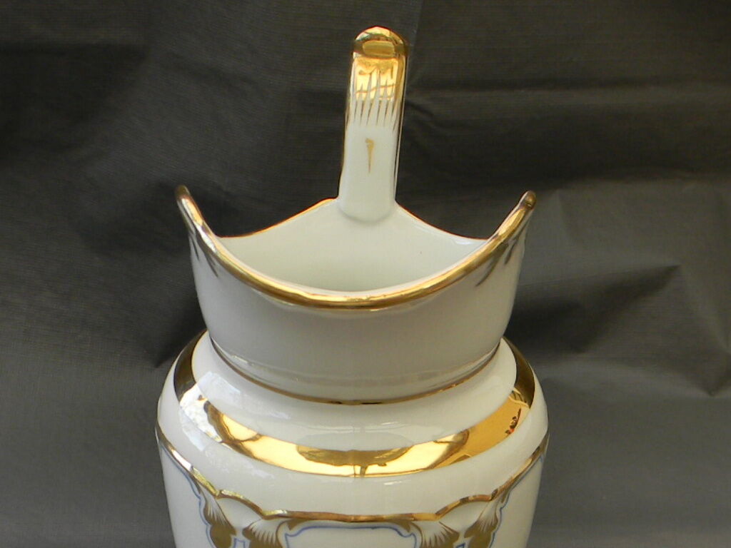 Milk jug or antique pitcher in white and gold porcelain.