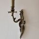 Pair of symmetrical gold wall sconces in baroque style made of bronze.