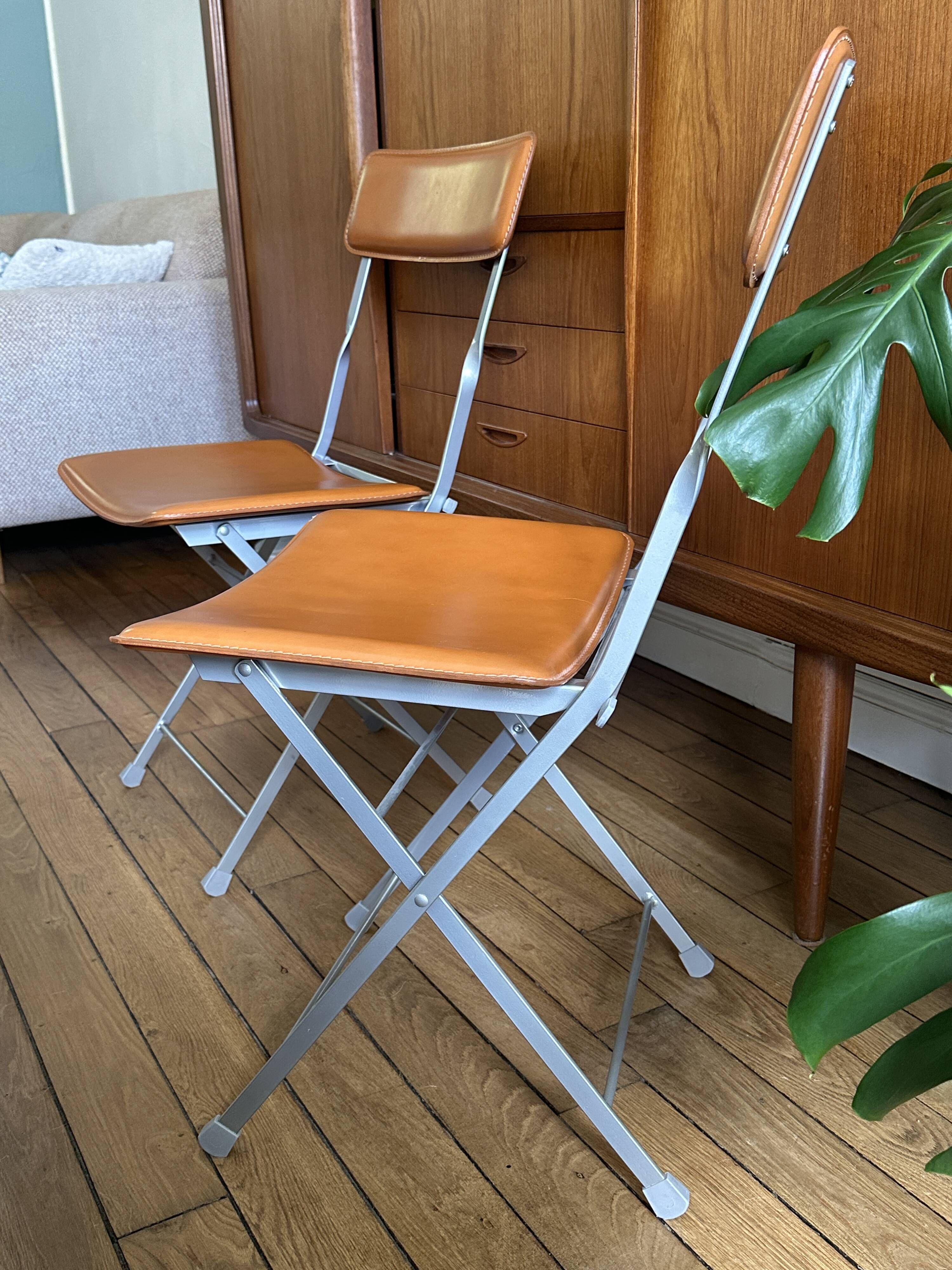 4 folding Sintesi chairs for DWR Lina in metal and vintage camel leather.
