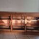 Antique wooden sideboard with three sliding glass doors.