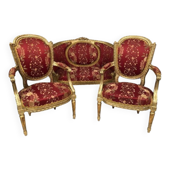 Partie de salon de style Louis XVI en bois doré. Canapé corbeille et paire de fauteuils