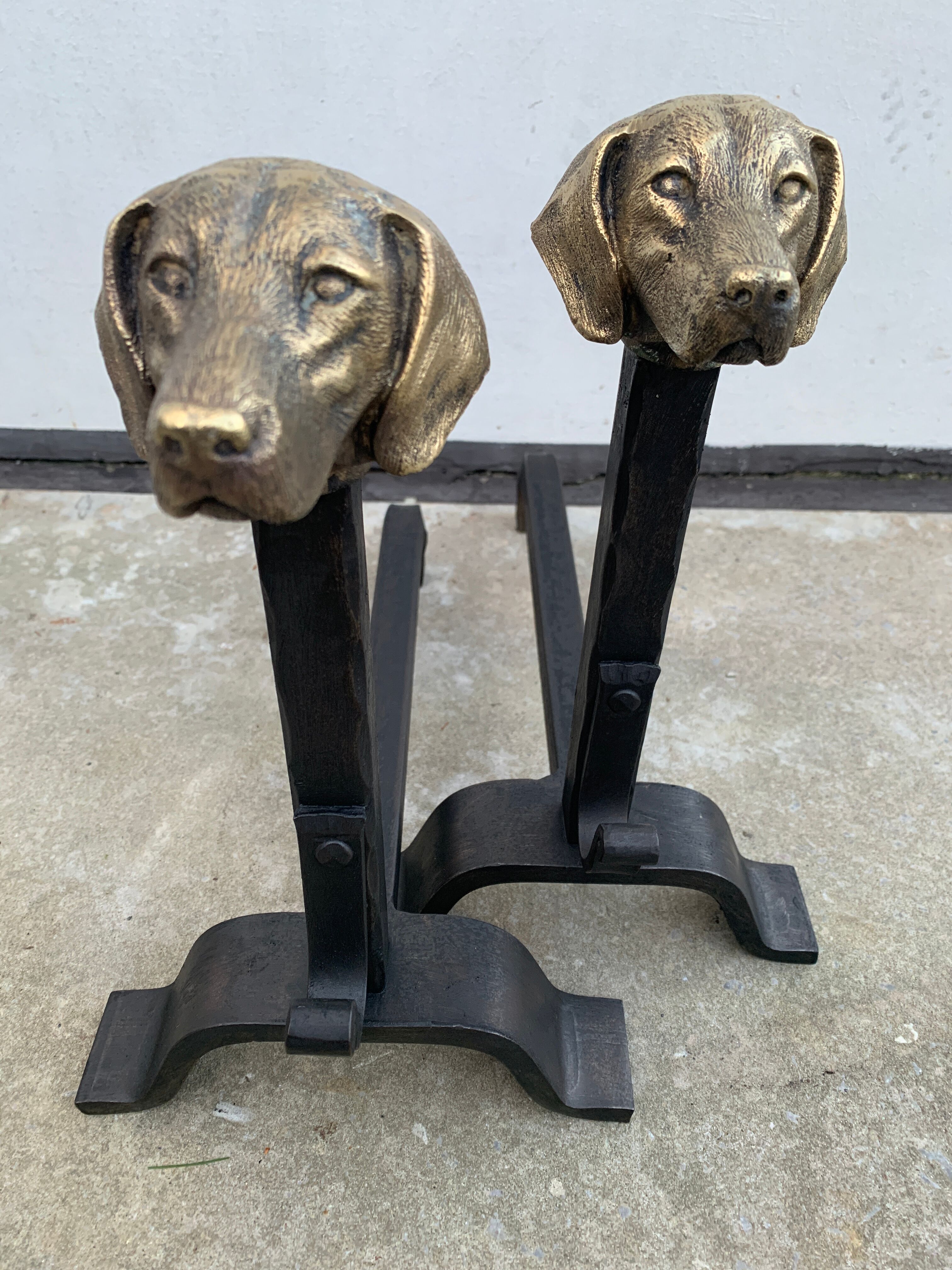 Pair of metal chenets decorated with brass dog heads